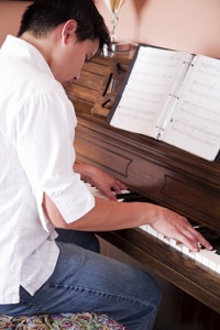 Un adolescent apprenant le piano avec la méthode Colin